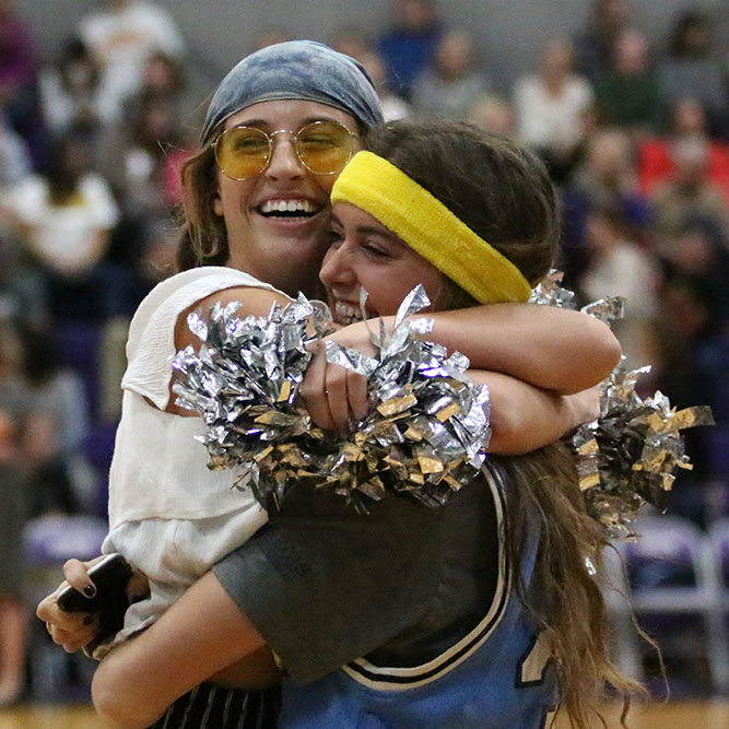 Before the Sion vs St. Teresas Academy basketball game Nov.17, senior Scream Team leader Mandy Mayer, left, hugs STA senior Monica Looney, right. Monica and I have been best friends since birth so even though we are rivals we still love to see each other every time we can, Mayer said.