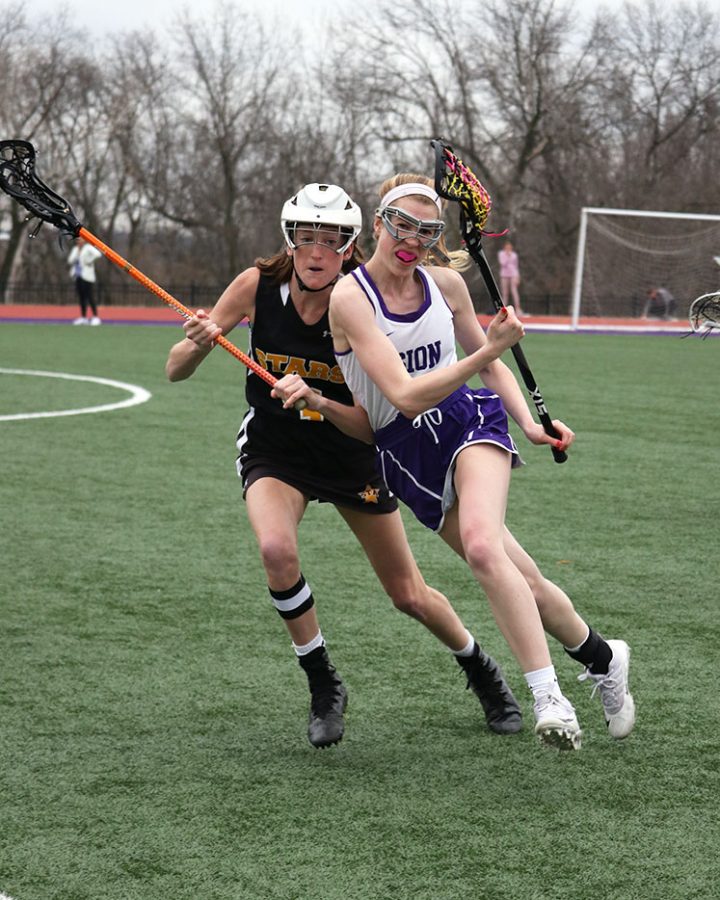 As sophomore attackman Delaney Minor carries the ball down the field, she gets up close and personal against St. Teresas Academys (STA) senior Rose Crowe April 4. Despite the home field advantage, the lacrosse team fell to STA 5-15. Playing against STA is very nerve-racking because they are our biggest rival, Minor said, although sometimes we do have losses, we know we leave it all on the field and thats all we can do.