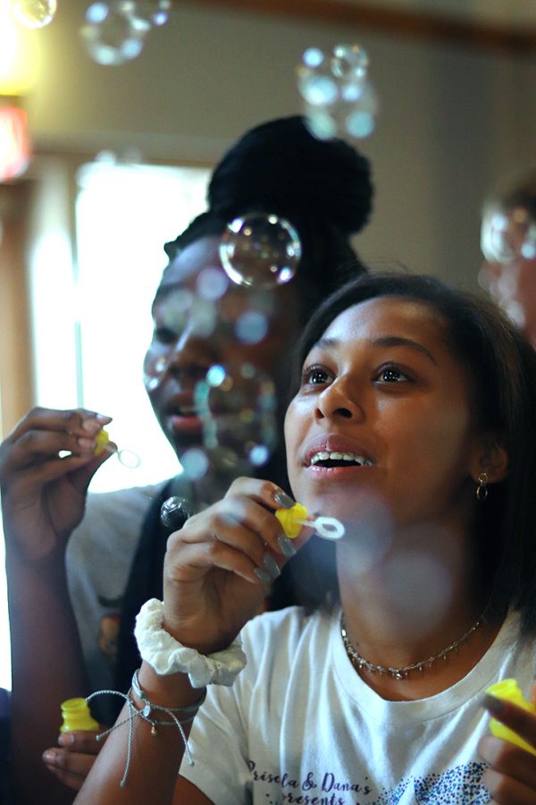 At the freshmen retreat, freshman Ellington Persley watches a bubble drift during one of the retreat activities Aug. 23 at the Heartland Retreat Center. Another activitity at the annual retreat was musical chairs sin music. “It was fun to interact with the other girls and see how far we could blow the bubbles,” Ellington said.