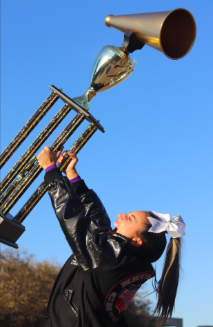 As the sun sets on the Fort Worth city skyline senior Bella Aquino hoists the national championship trophy above her head March 7. The cheer team placed first in their national competition, the only competition they got to compete in due to the cancellation of Regionals to qualify for State. It made me feel like I was on top of the world, Aquino said. All of Coach Tabbys and the seniors hard work these past four years finally had paid off.
