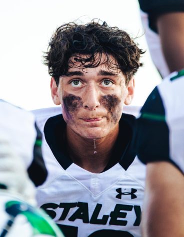 Studying film, senior Draiden Parks concentrates on the sideline of the varsity home game against. Lees Summit High School Sept. 2. The Falcons lost to the Tigers 45-28.