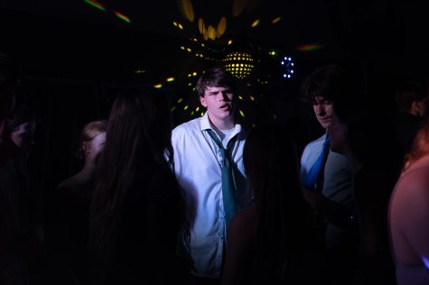 Noah Garthe looking through the crowd on the dance floor at the Homecoming dance. The dance attracted more than 1,400 students to it as it returned in the large gym after last year's dance was held on the football field. 