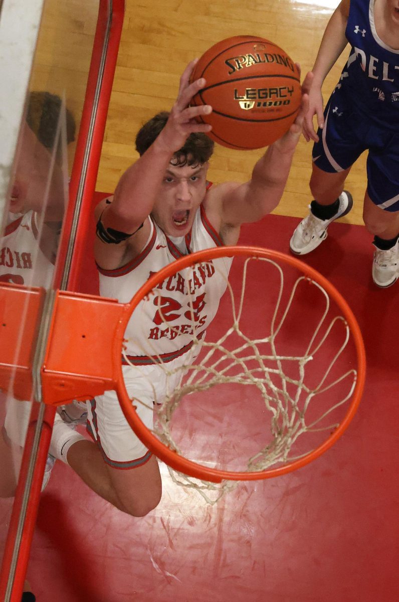 Richland senior Tucker Hughes put down a dunk in the second half as the #1 seeded Richland Rebels complete the three-peat tonight, defeating the #2 ranked Delta Bobcats 80-67 in the Class 1, District 2 tournament, giving Richland three district championships in a row. This is the first time in Richland school history the Rebels have won three straight district championships.