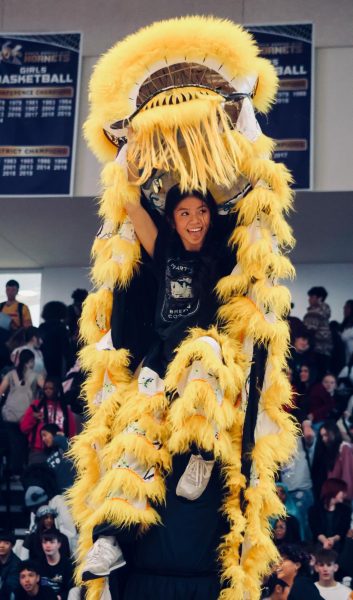 HERE ME ROAR: At the Multicultural Festival assembly on Dec. 5, junior Lynn-Truc Nguyen is lifted by her partner to reveal her identity at the end of the Lion Dance. This performance represented one of the many cultures celebrated at NKC's fifth annual Multicultural Festival event. The Lion Dance is a traditional Chinese performance where dancers perform in a colorful lion costume to bring good fortune and chase away negative energy.