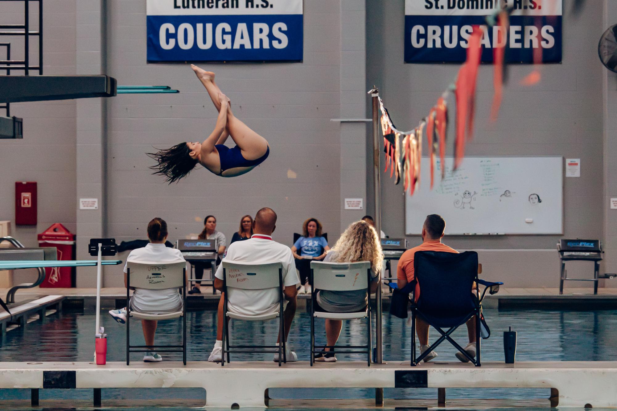 The judges watch as Audrey McCann performs a backwards dive on Feb. 5. McCann ended GACs in first place.