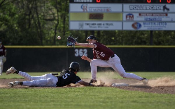 Sophomore Grant Dinges (12) catches the ball to get a pickoff of junior Noah Johnson (5) of the Lafayette Lancers. Summit defeated the Lafayette Lancers on April 14 with a final score of 12-4. “I [call a pick] whenever there is a fast runner at second or their lead is getting really big,” Dinges said.